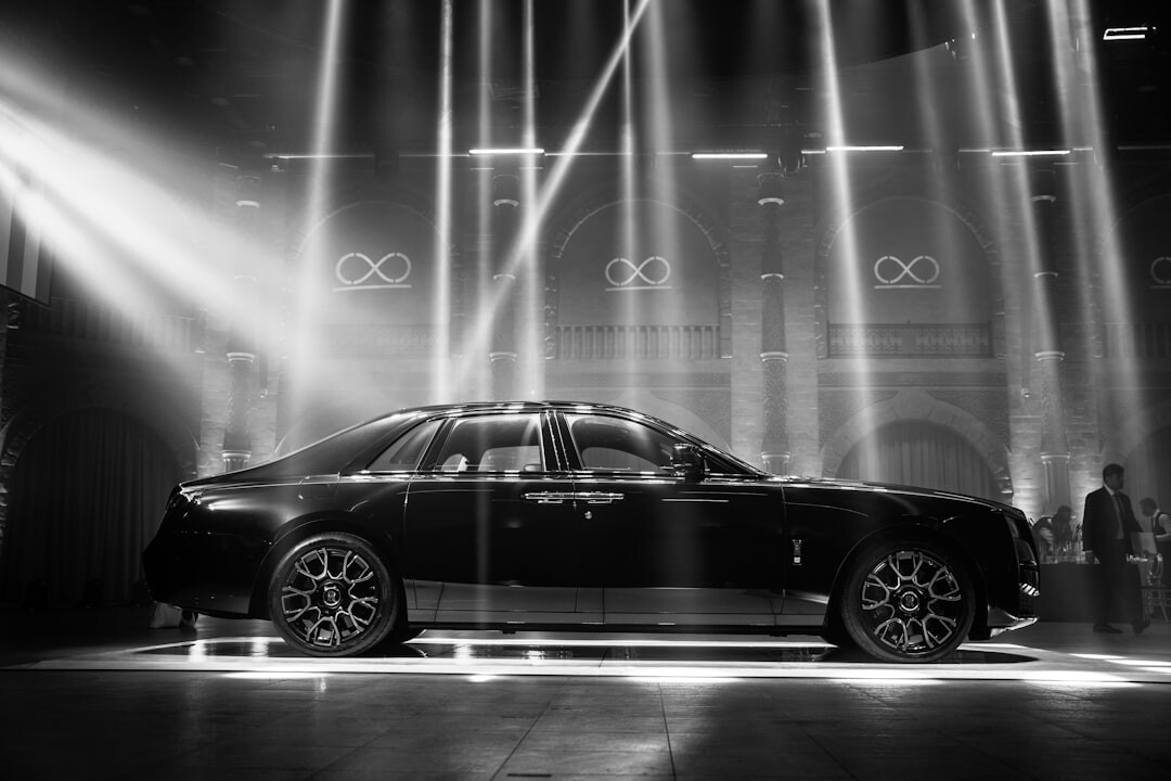 Grand exhibition hall showcasing luxury automobiles under dramatic lighting