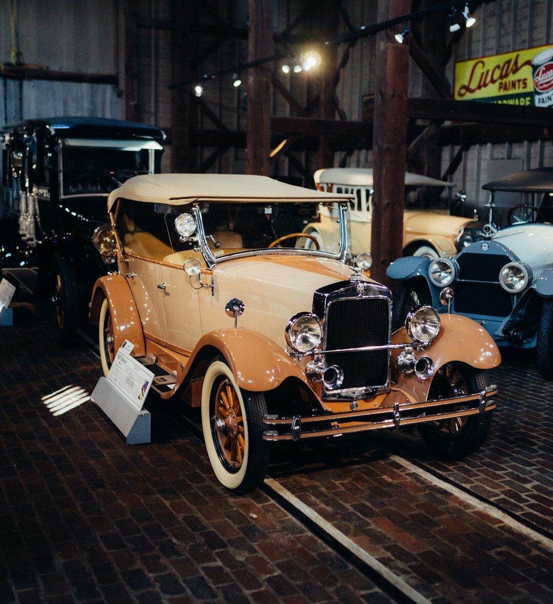 Historic brick garage filled with vintage automobiles under warm light