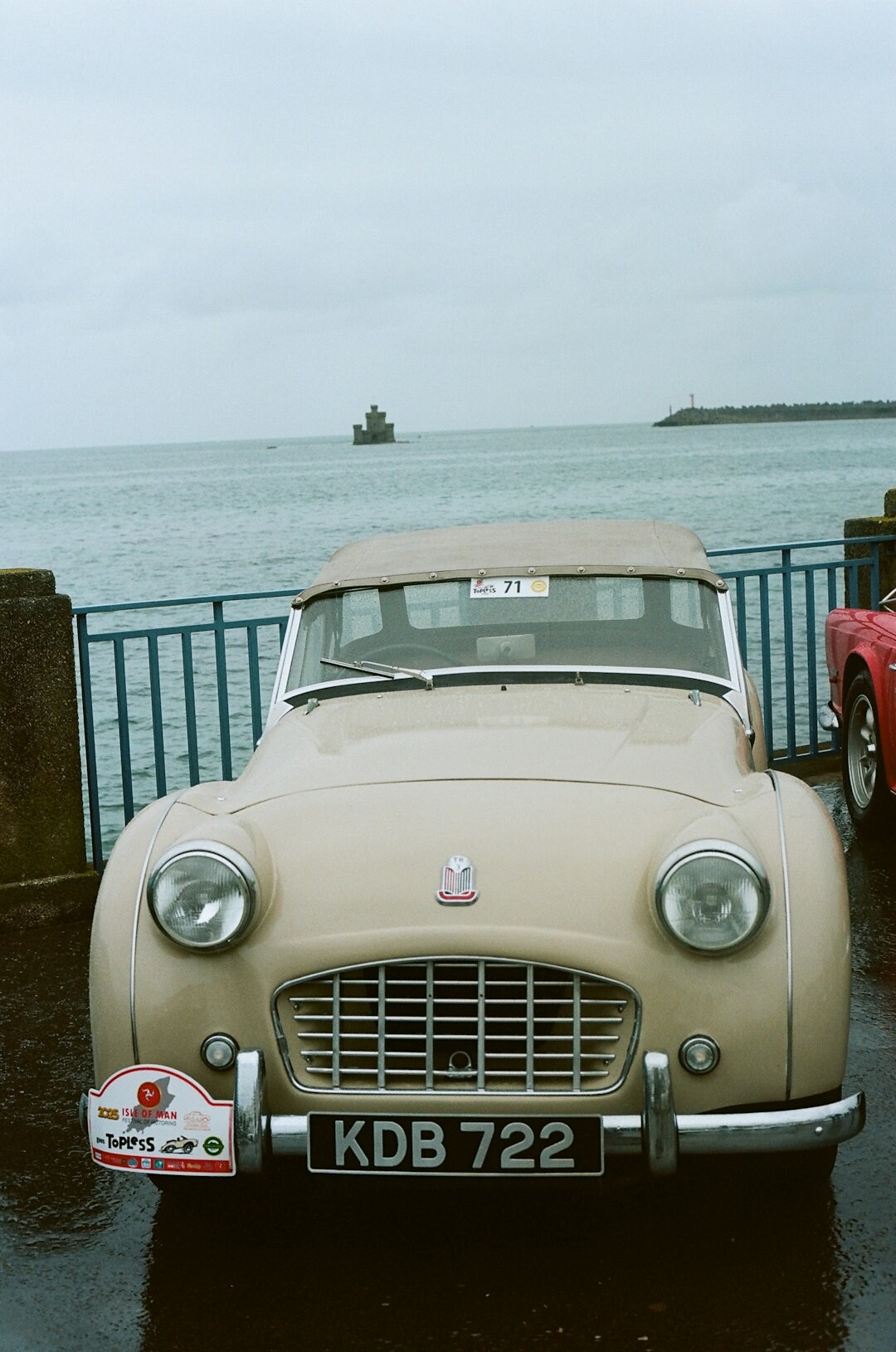 Row of classic automobiles lined up at an outdoor coastal exhibition